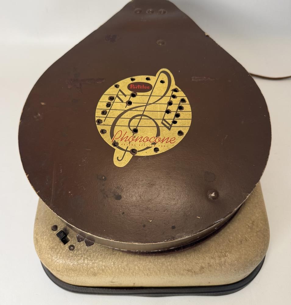 Montgomery Ward Portelec Phonocone Portable Phonograph Model 64 BR-1901 B: This item is located on the second floor. This Montgomery Ward Portelec Phonocone, model number 64 BR - 1901 B, is a portable phonograph. The unit features a brown teardrop-shaped lid and a light tan,