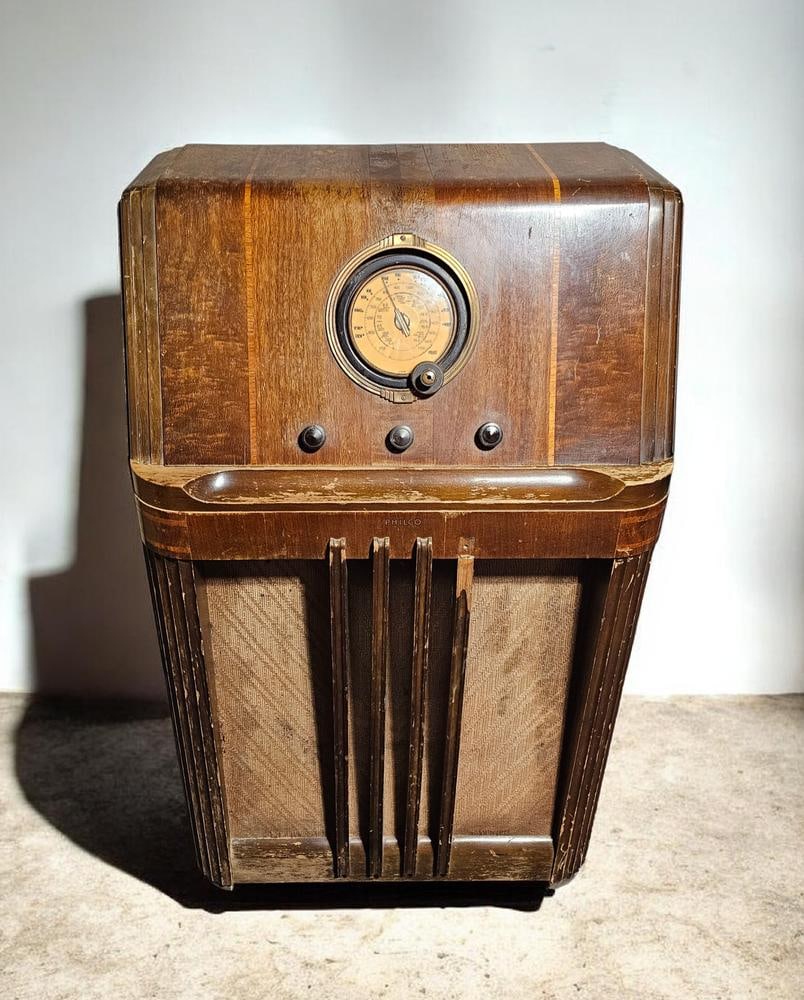 Philco Model 38-4 Console Radio: Measures 41 x 25 x 15 inches The cabinet exhibits significant cosmetic wear, including widespread scuffs, scratches, and areas of missing or peeling veneer, notably along the front edges and horizont