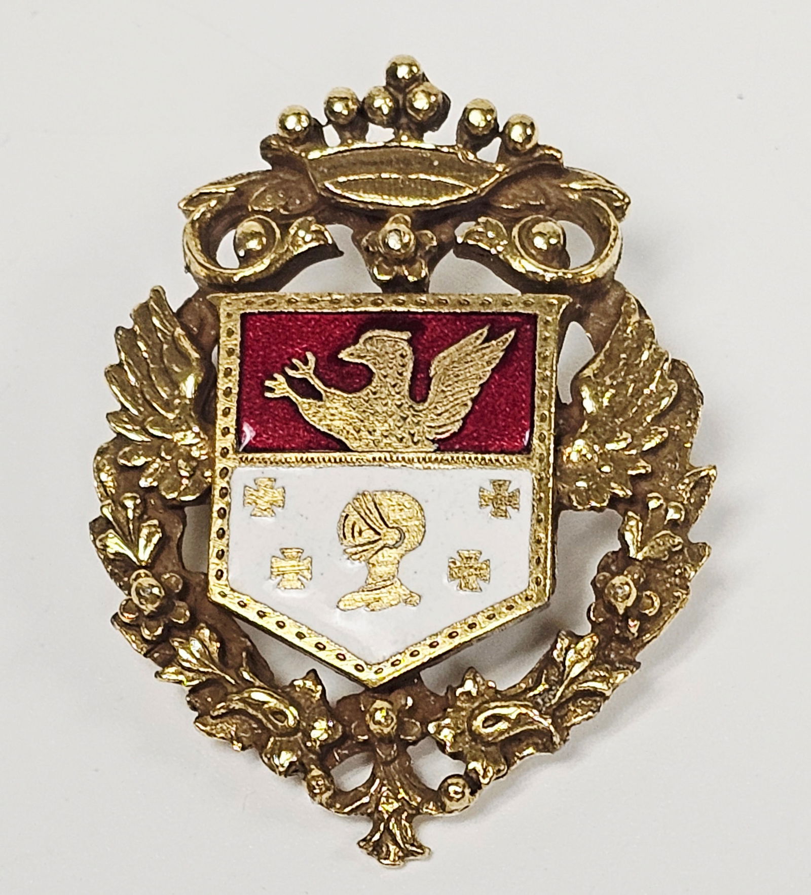 Vintage Coro Coat of Arms Enamel Brooch: A vintage 1940s Coro heraldic coat of arms brooch, model number 763, featuring a shield design in gold-tone metal with red and white enamel accents. The central shield is divided horizontally, with