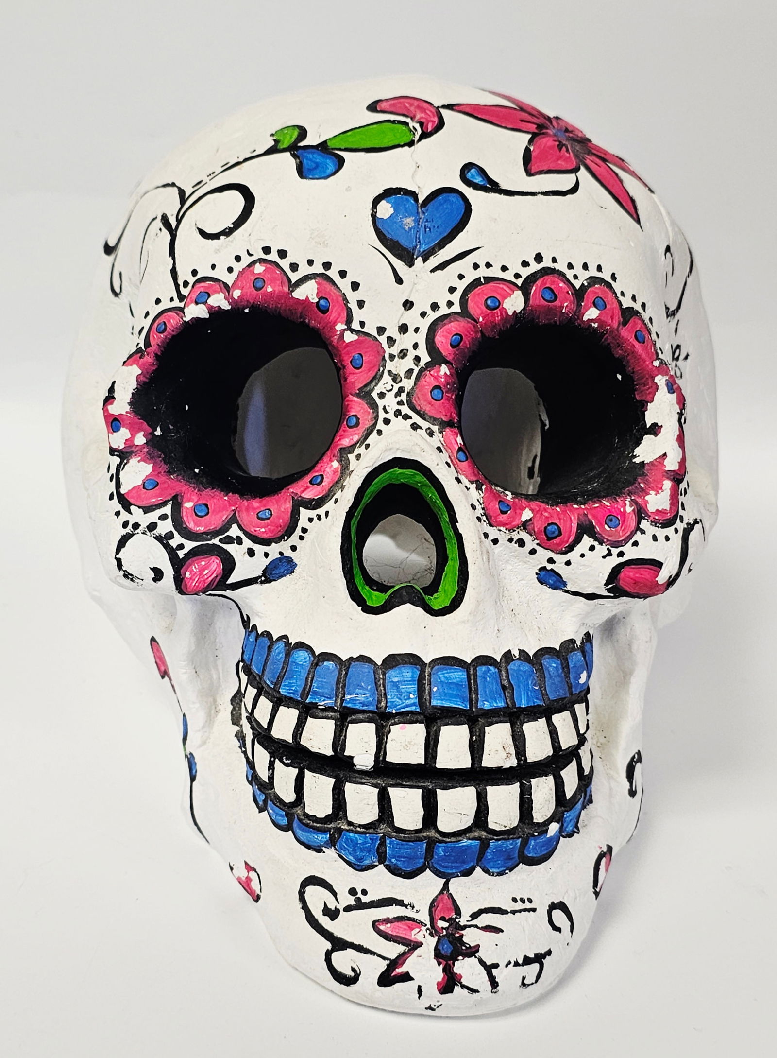 Hand-Painted Day of the Dead Style Ceramic Calavera Skull: This decorative skull is a hand-painted piece of folk art, crafted from molded unglazed ceramic in the tradition of a Mexican calavera for the Day of the Dead. The object features a matte white