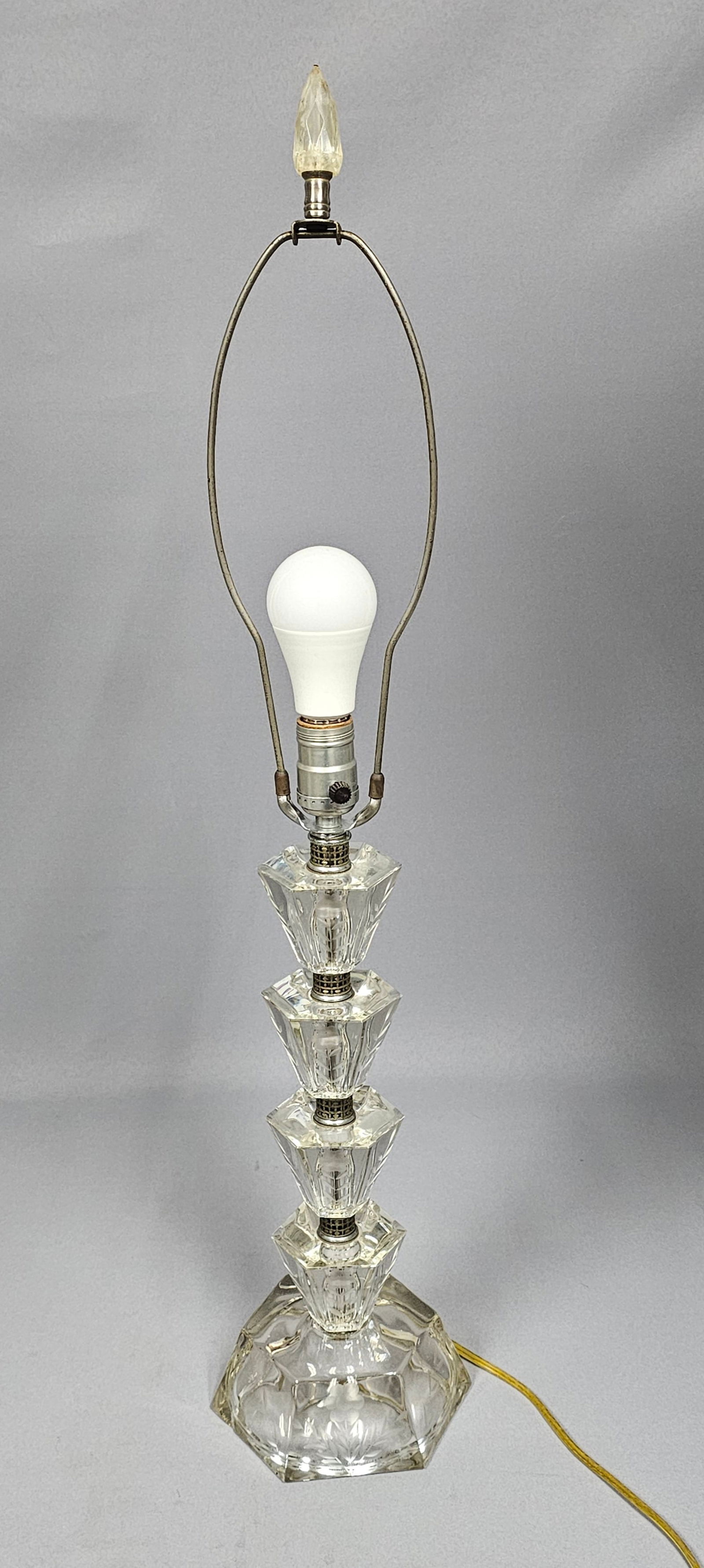 Vintage Etched and Faceted Crystal Stacked Column Table Lamp: This vintage table lamp features a central column composed of four stacked, faceted glass sections, each intricately decorated with etched floral and foliate motifs. The column is supported by a subst