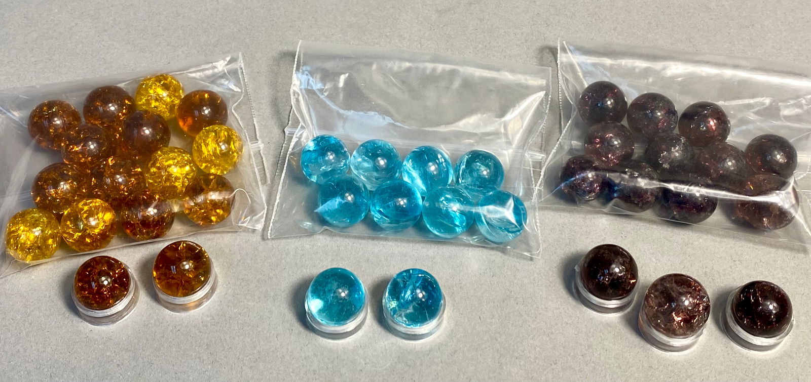 Unattributed, Crackle Glass Marble Collection, Tri-Color Assortment, Late 20th Century: This collection consists of a series of machine-made glass spheres featuring a distinctive crackle finish, often referred to in the trade as fried marbles. The assortment is presented in three primary