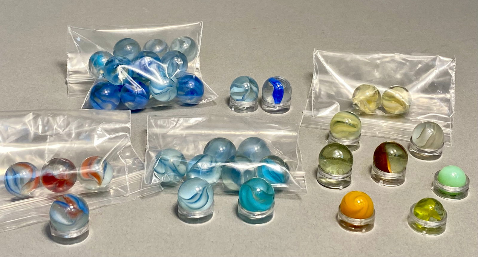 Collection of Vintage Vitro Agate and Assorted Glass Marbles, Cat's Eye and Swirl Patterns, mid-20th: This diverse collection features an assortment of vintage machine-made glass marbles, primarily dating from the mid-20th century. The lot includes a variety of styles such as "Cat's Eye" mar