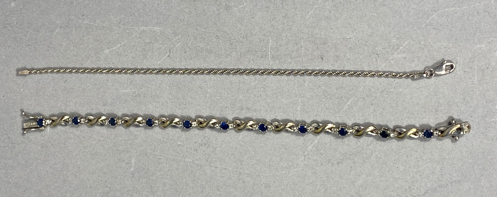 Sterling Silver Sapphire and Diamond Accent Infinity Link Bracelet and Italian Rope Chain 12.09g: A pair of sterling silver bracelets. The first is a link bracelet featuring alternating polished infinity-style links and round-cut dark blue stones, possibly sapphires, each flanked by two small clea