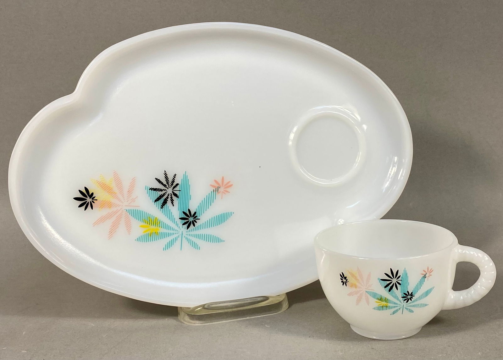 Mid-Century Modern Federal Milk Glass Atomic Flower Snack Set: A two-piece snack set attributed to the Federal Glass Company, comprising a kidney-shaped tray and a matching cup. The set is constructed from pressed white opaque milk glass and features the "At