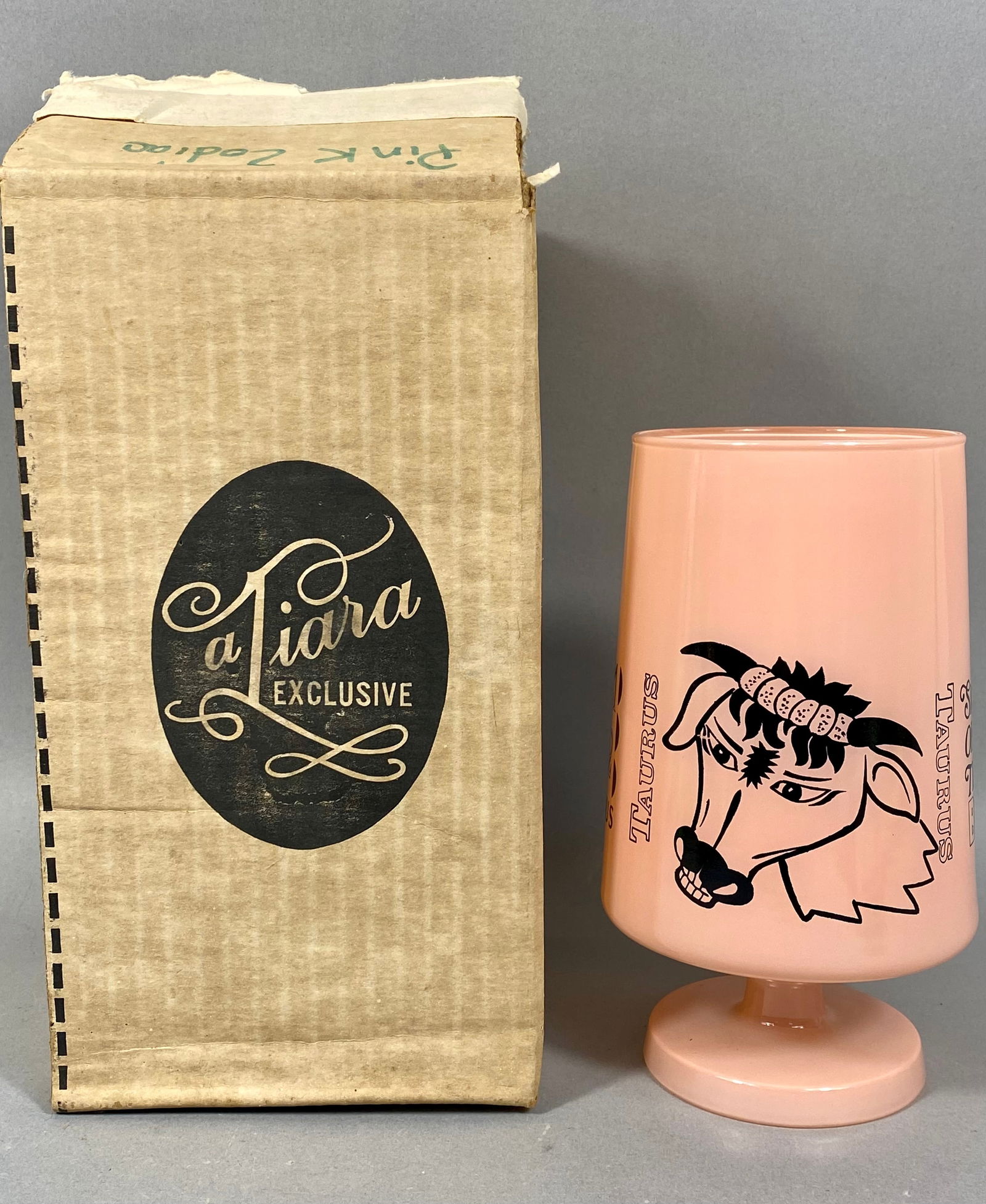 Tiara Exclusive Pink Opaque Glass Taurus Zodiac Goblet with Original Box: This goblet is manufactured by Tiara Exclusive, as identified by the original manufacturer packaging. The item is crafted from pink opaque glass and features a chalice-style body on a circular pedesta