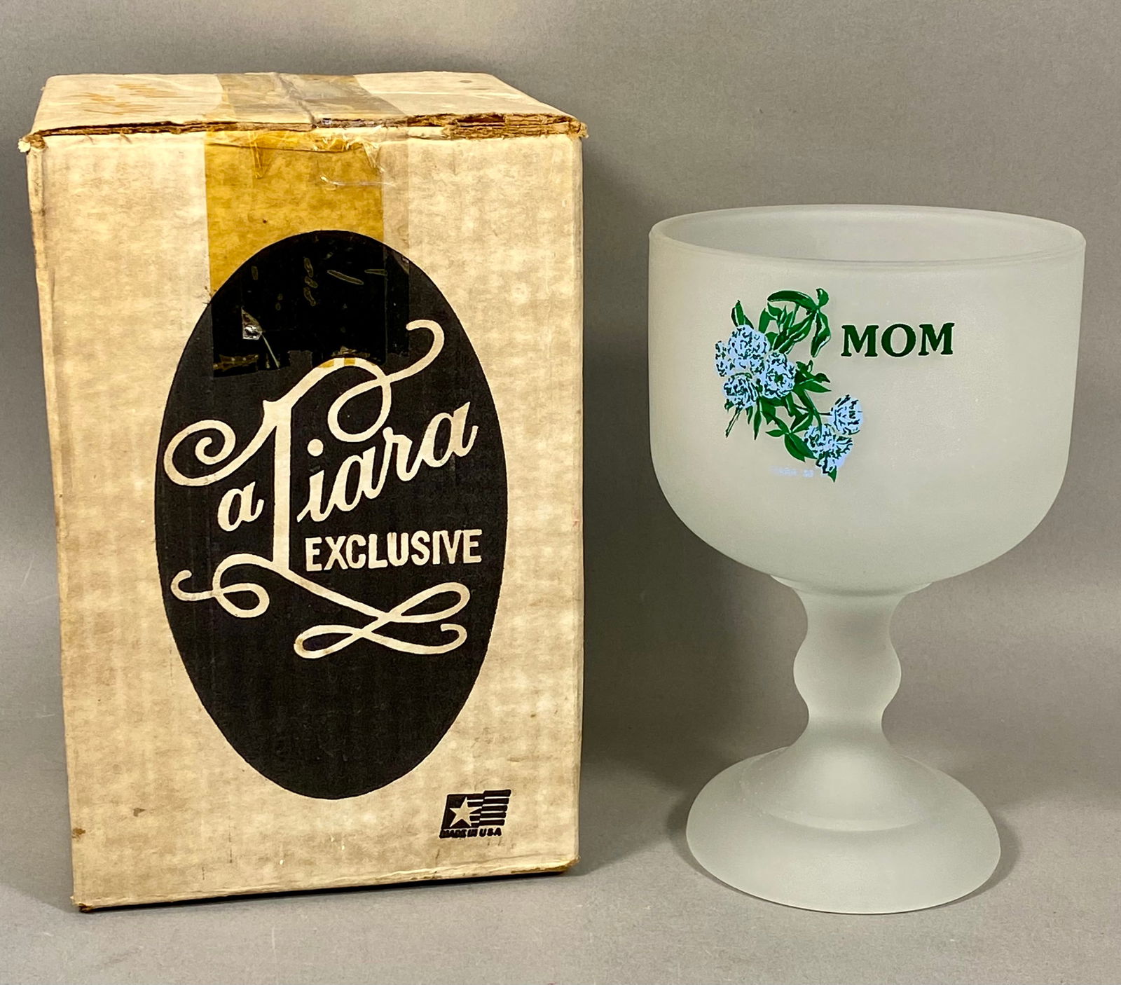 Tiara Exclusives Frosted Glass Mom Goblet with Original Box, 1986: This frosted glass goblet was marketed by Tiara Exclusives and manufactured by the Indiana Glass Company. The pressed glass vessel features a satin finish, a baluster-form stem, and a circular foot. T