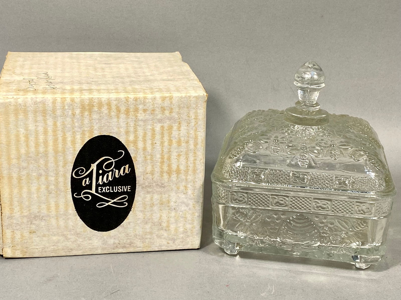 Tiara Exclusives Beehive and Bee Pattern Covered Honey Dish: A vintage pressed soda-lime glass covered honey dish produced for Tiara Exclusives, manufactured by the Indiana Glass Company, circa 1970s. This rectangular, footed piece features the "Beehive an