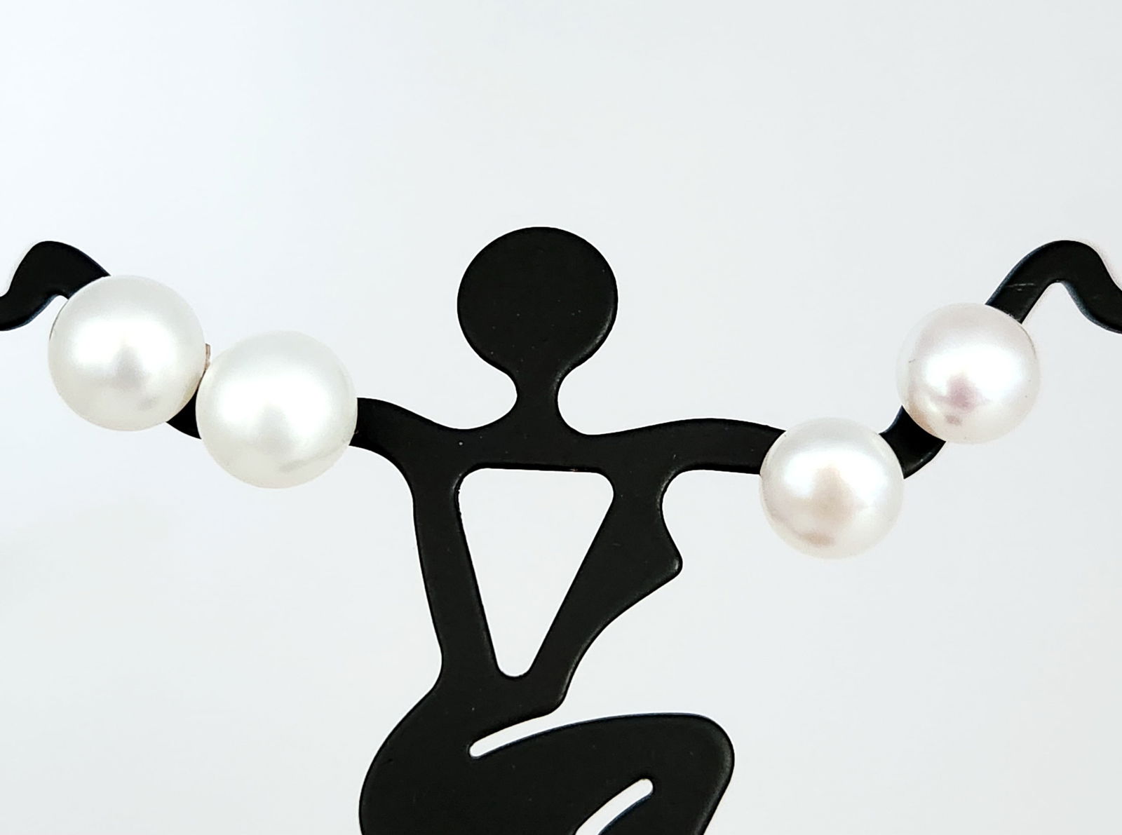 14K Gold Pearl Stud Earrings 5.6 Grams: A pair of pearl stud earrings. Each earring features a round pearl with a white-to-cream color and a smooth surface. The pearls are mounted on 14K yellow gold posts and are secured by 14K yellow gold