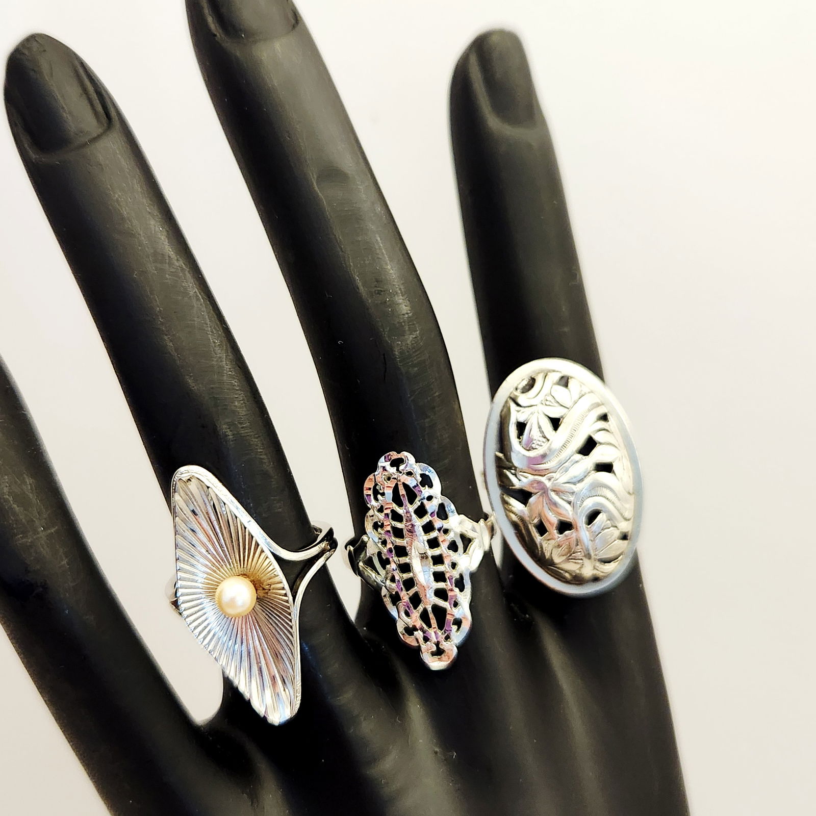 Sterling Beaucraft Rings 9.2 Grams: Trio of mid-20th-century rings manufactured by Beaucraft Inc. Design types include openwork floral, openwork lattice, and sunburst with pearl. Hallmarked BEAU-STERLING and STERLING. Beaucraft was a pr