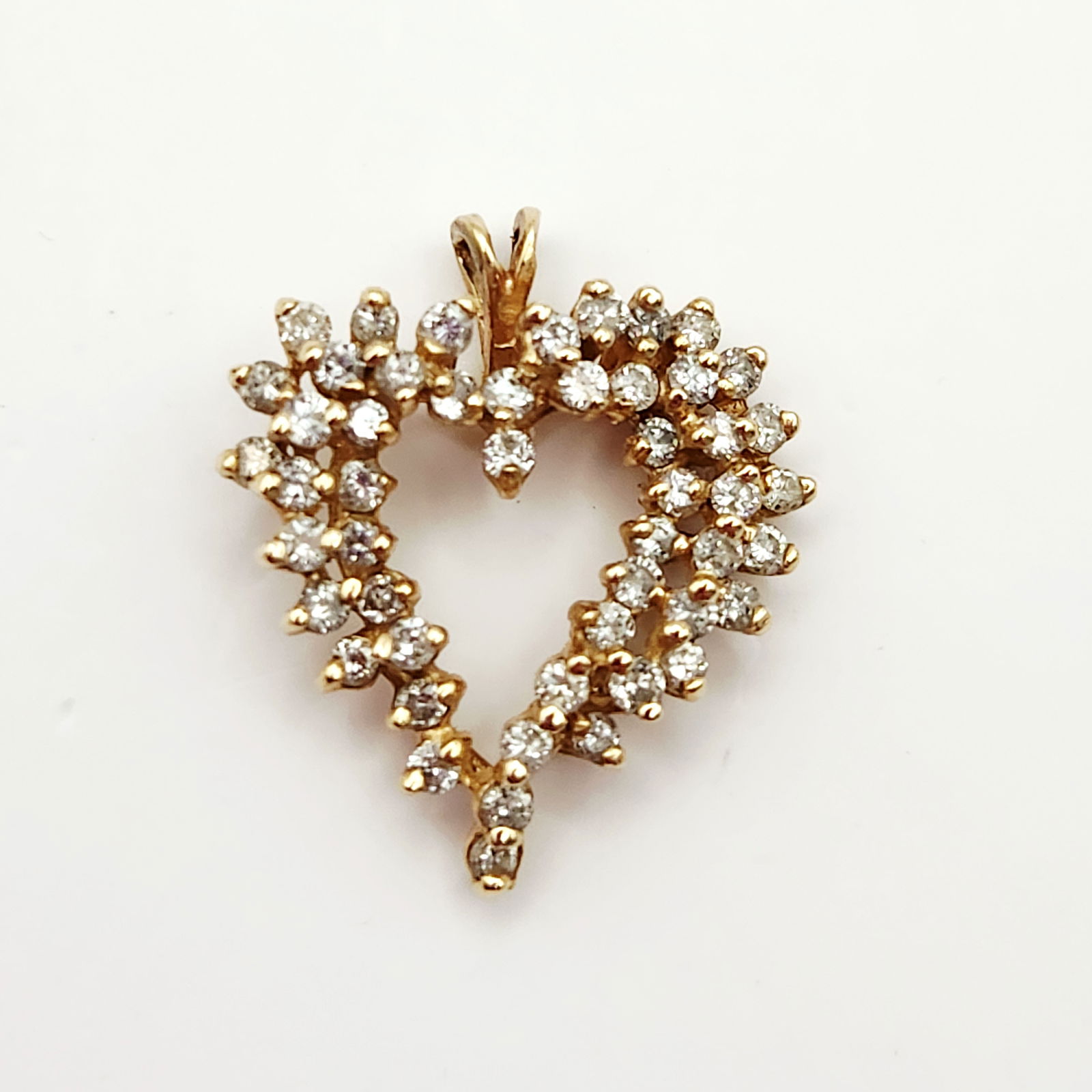 14K Gold & Diamond Heart Pendant 2.9 Grams: This heart-shaped pendant is crafted in 14K yellow gold featuring an intricate openwork design. The piece is densely set with numerous round brilliant-cut diamonds. The stones are arranged in multi-le