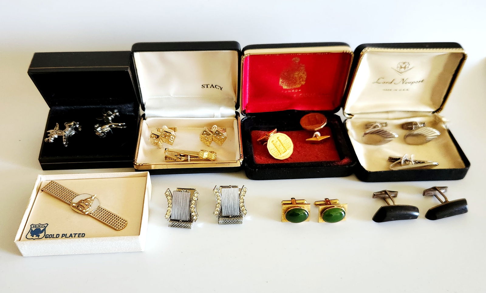 A Collection of Gold-tone and Silver-tone Cufflinks and Tie Clips: A collection of gold-tone and silver-tone cufflinks and tie clips featuring various designs including dice, donkeys, and architectural motifs, with individual pieces ranging from approximately 0.75 to