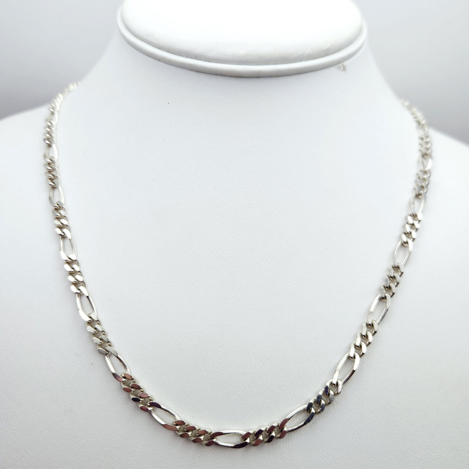 Sterling Figaro Link Necklace 27.2 Grams: A sterling silver figaro link chain necklace measuring 30 inches in length and weighing 27.2 grams, featuring a lobster clasp and stamped 925 Italy and LEH. Good vintage condition.