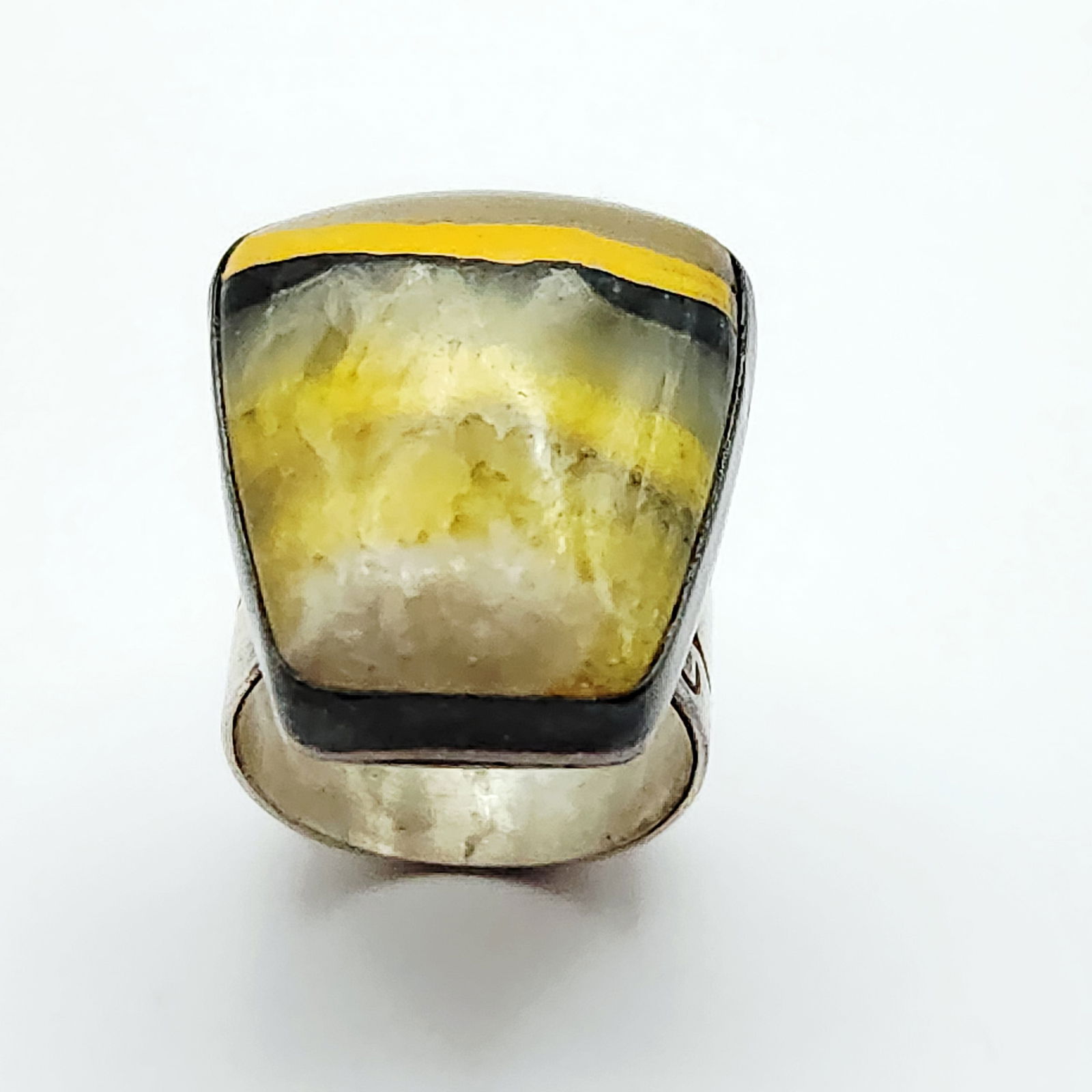 Sterling Bumblebee Jasper Ring 11.9 Grams: This sterling silver statement ring centers a large, rectangular cabochon that appears to be bumblebee jasper, showcasing its characteristic banding in shades of yellow, black, and grey-white. The sto