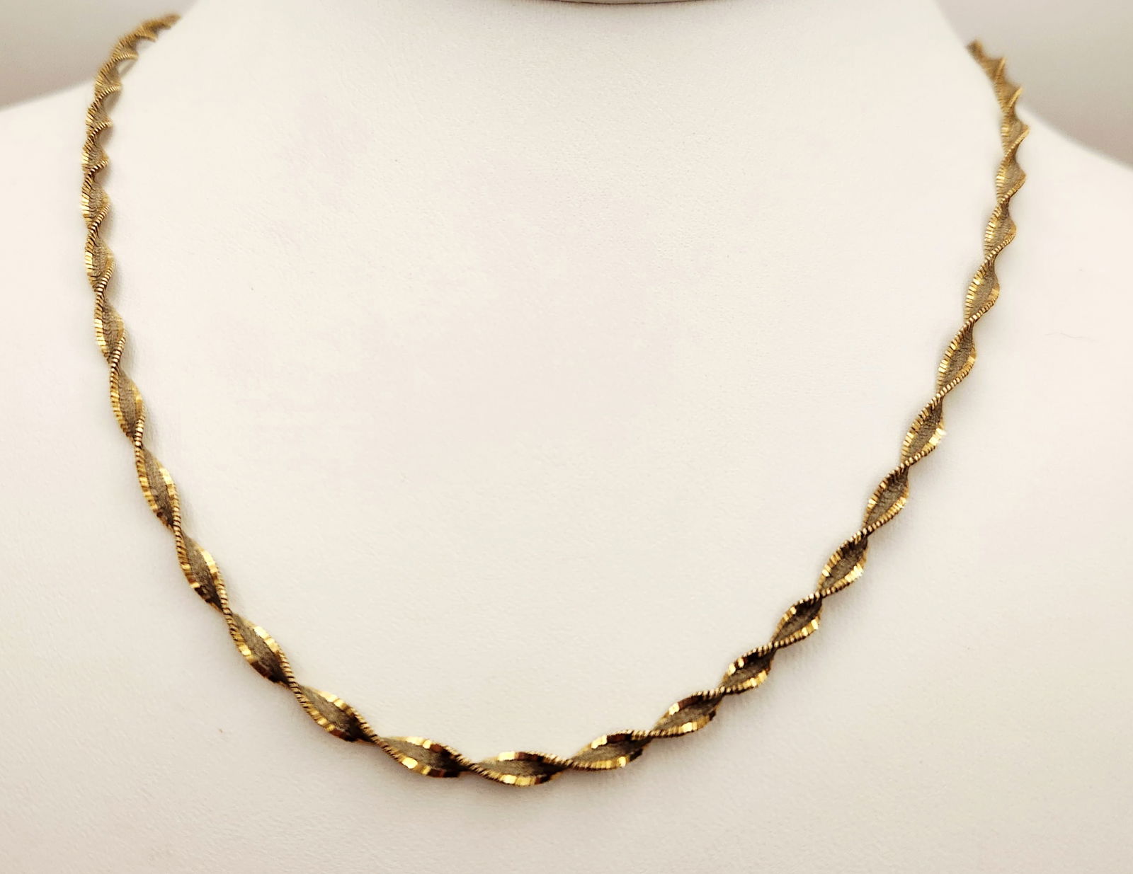 Sterling & Vermeil Twisted Necklace 6.8 Grams: This 18-inch necklace features a twisted flat-link construction composed of alternating Vermeil & sterling scrolled links. The piece is secured with a lobster claw clasp. The end caps are stamped