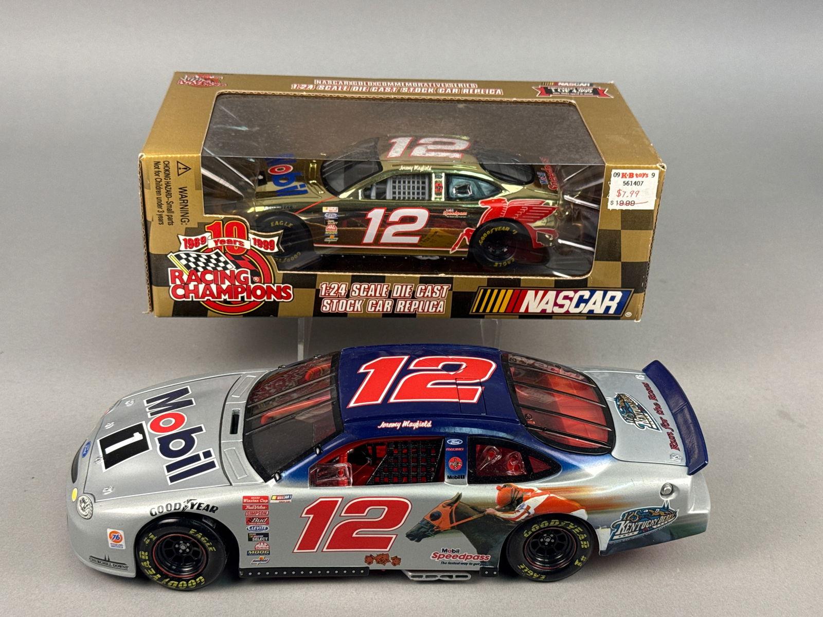 A Pair of Racing Champions Jeremy Mayfield #12 Mobil 1 Ford Taurus NASCAR Die-Cast Replicas, 1999: This lot features a pair of 1:24 scale die-cast metal NASCAR stock car replicas manufactured by Racing Champions, both representing Jeremy Mayfield's #12 Mobil 1 Ford Taurus from the 1999 racing seaso