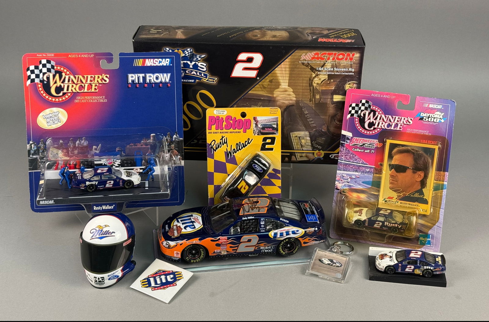 A Collection of Rusty Wallace NASCAR Signed Die-Cast Vehicles and Memorabilia: A collection of NASCAR memorabilia primarily featuring driver Rusty Wallace, including die-cast vehicles and promotional items from manufacturers such as Action Performance, Winner's Circle, and Racin