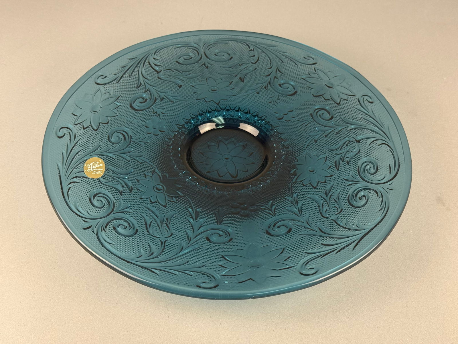 Tiara Exclusives, Pressed Glass, Sandwich Pattern Platter: A spruce blue pressed glass platter produced by Tiara Exclusives and manufactured by the Indiana Glass Company. This piece features the elaborate Sandwich pattern, characterized by intricate floral an