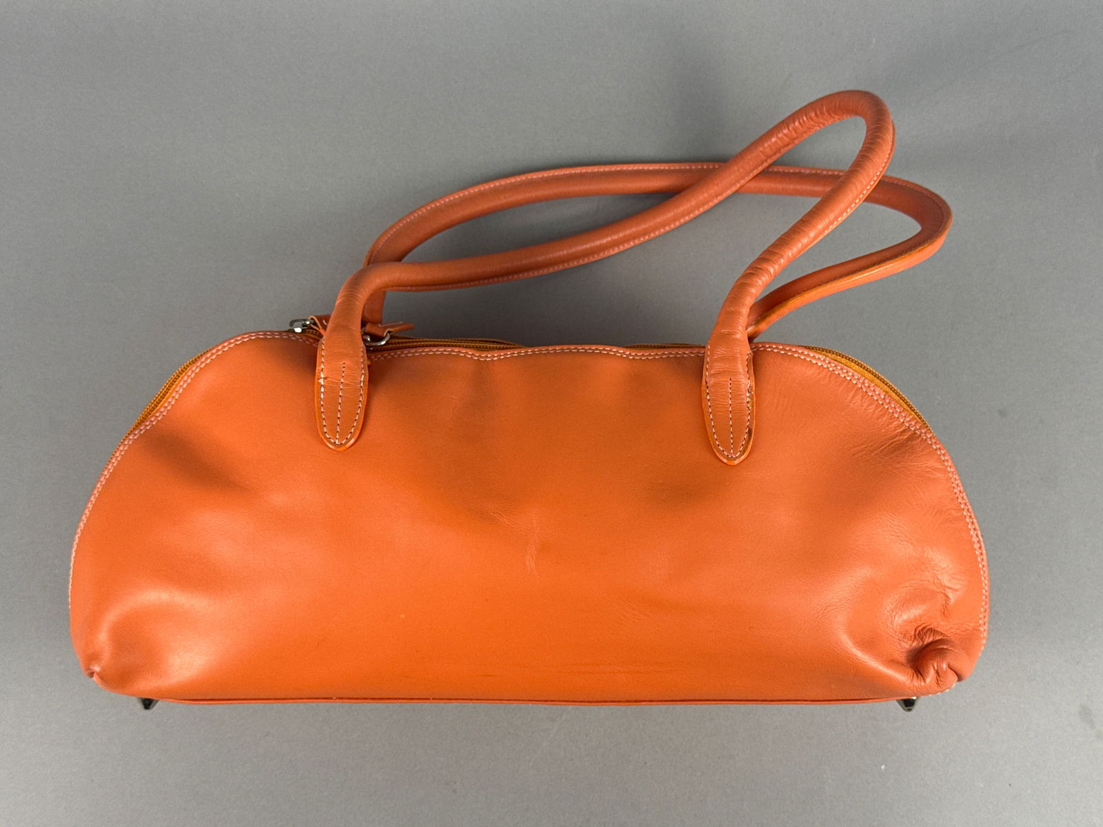 Terry Lewis Classic Luxuries Elongated Bowler Shoulder Bag, Orange Leather: A professional shoulder bag by Terry Lewis Classic Luxuries, featuring a structured, elongated bowler-style silhouette. Crafted from vibrant orange smooth leather, the exterior is designed with a mini