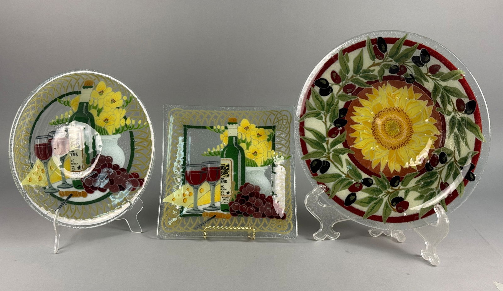 Peggy Karr (American, 20th/21st Century) 'A Trio of Tuscany Fused Glass Plates and Bowls': Peggy Karr (American, 20th/21st Century). A collection of three decorative fused glass vessels featuring Mediterranean-inspired motifs. The group includes a large circular shallow bowl centered with a