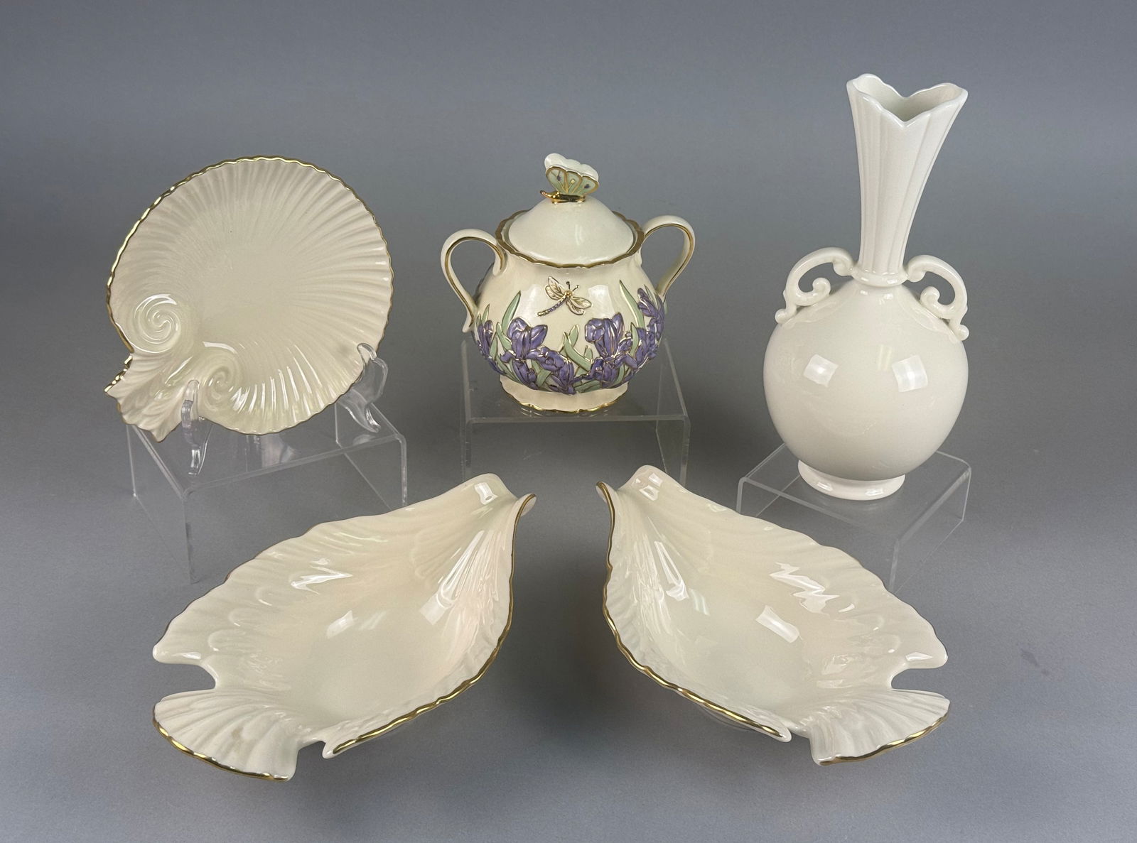 A Collection of Lenox Ivory Porcelain Decorative Items Including a Bulbous Bud Vase and Aegean Dish: A collection of Lenox ivory-toned fine porcelain decorative items featuring various botanical and classical motifs. The group includes a bulbous bud vase with twin scroll handles and a fluted rim, a s