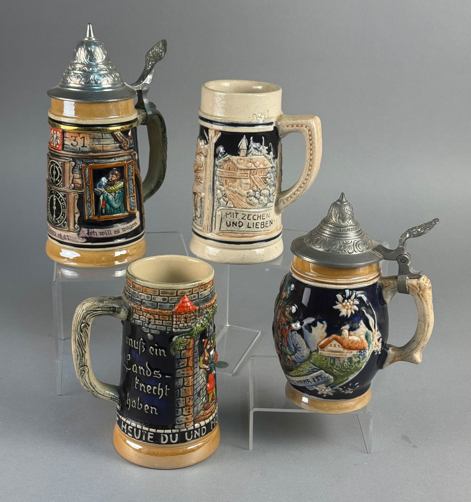 A Collection of Gerz and Thewalt West German Ceramic Beer Steins: A collection of relief-molded and hand-painted glazed ceramic beer steins produced by manufacturers including Gerz and Thewalt. The group features traditional Bavarian folk scenes, such as landsknecht