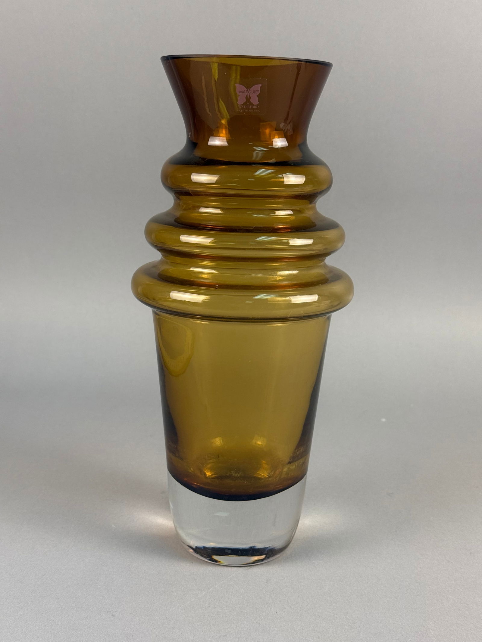 Marquis by Waterford, Hand-Blown Amber Glass Tornado Vase: A modernist art glass vase produced by Marquis by Waterford in Poland. This piece features a vibrant honey-toned amber body with a flared rim and a distinctive triple-annulated ring design around the