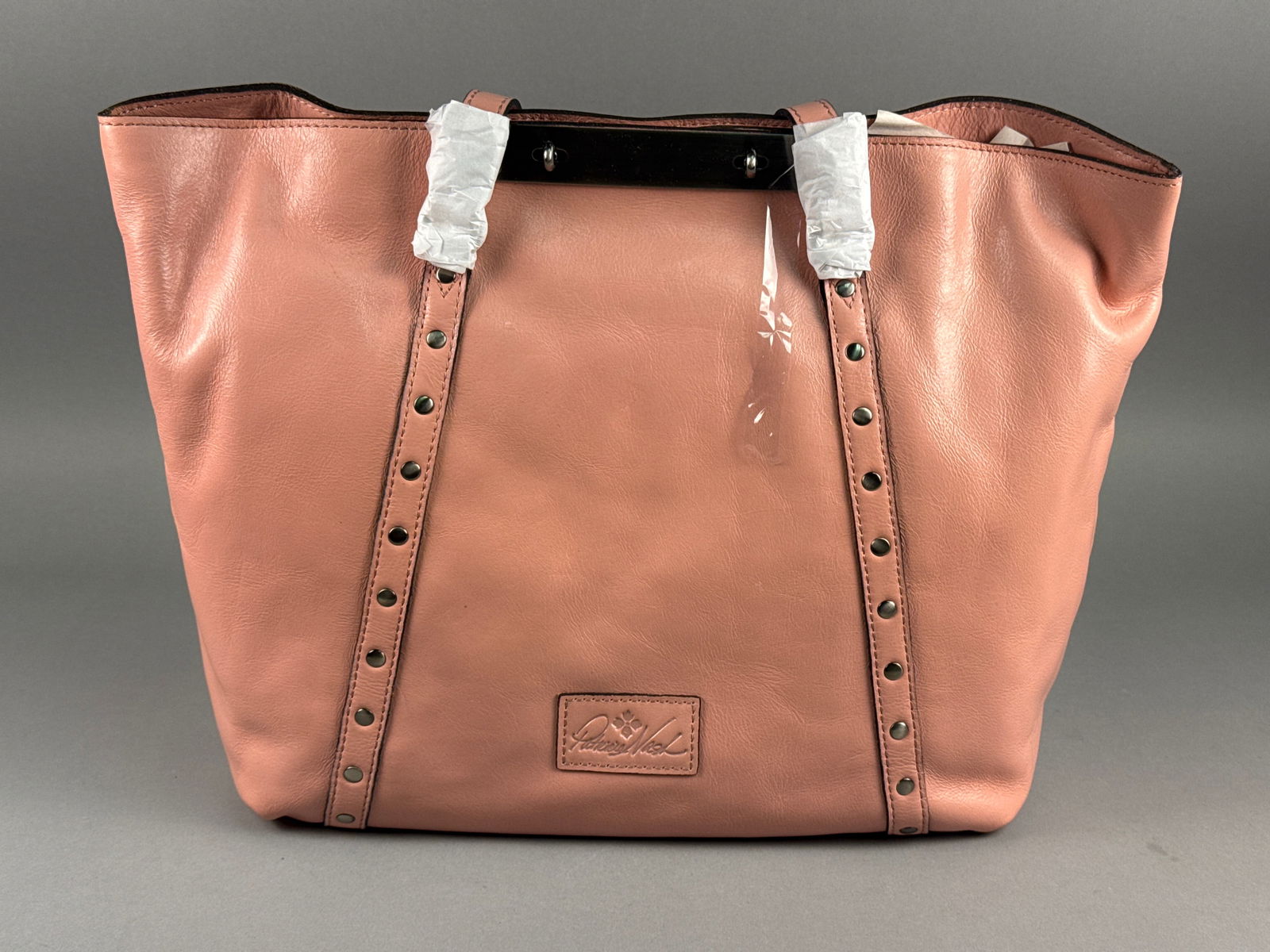 Patricia Nash Benvenuto Distressed Leather Tote, Lobster Bisque: This Patricia Nash Benvenuto tote is crafted from high-quality distressed leather in a muted coral-pink shade known as Lobster Bisque. The exterior features vertical bands of antique silver-tone studs
