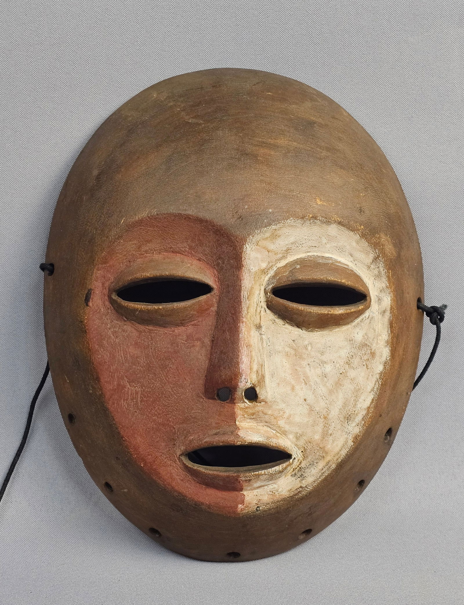Mid-20th Century Lega Wooden Anthropomorphic Face Mask: This hand-carved Lega wooden anthropomorphic face mask originates from Central Africa and is characteristic of the artistic traditions of the Bwami society. Height: approximately 10 inches The item
