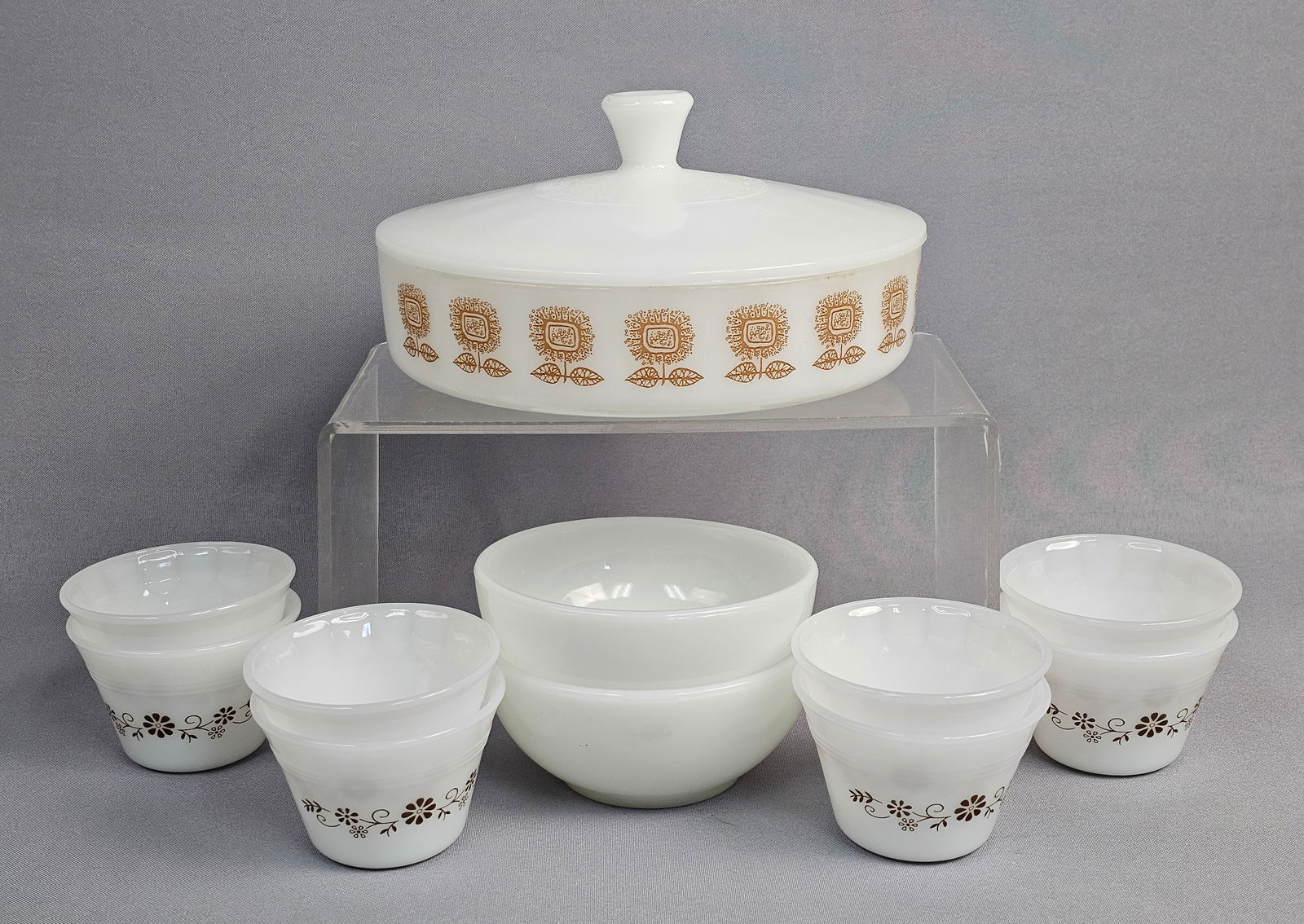 Federal Milk Glass Golden Sunflower Casserole Dish and Associated Kitchenware: This collection of mid-century milk glass kitchenware features a round covered casserole dish and matching lid produced by the Federal Glass Company in the Golden Sunflower pattern. The dish is decora