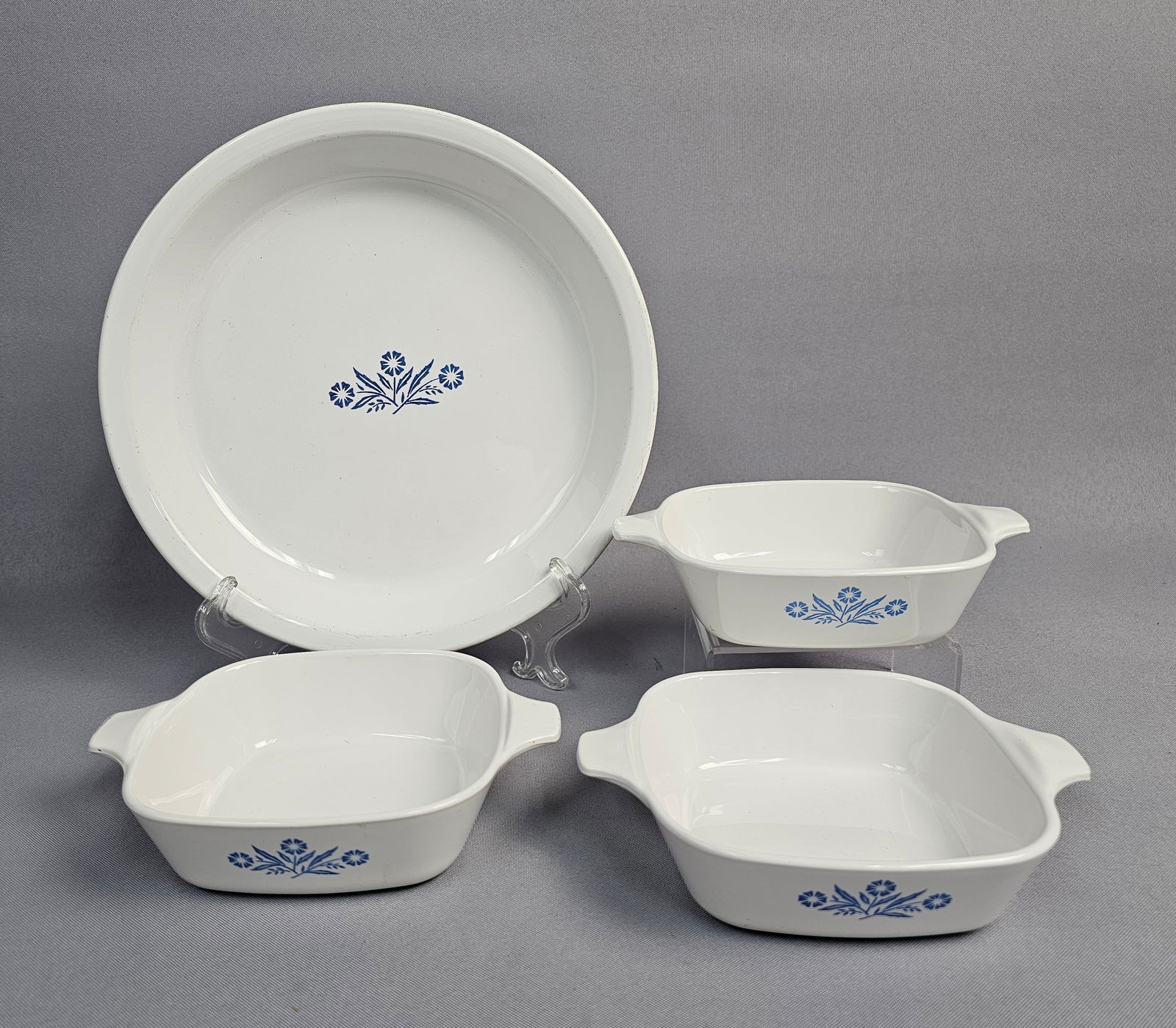 A Collection of Corning Ware Blue Cornflower Pattern Cookware: A collection of Corning Ware cookware in the Blue Cornflower pattern. The group is constructed from white pyroceram and includes a round pie plate, model P-309, and square petite pans, model P-41-B. E