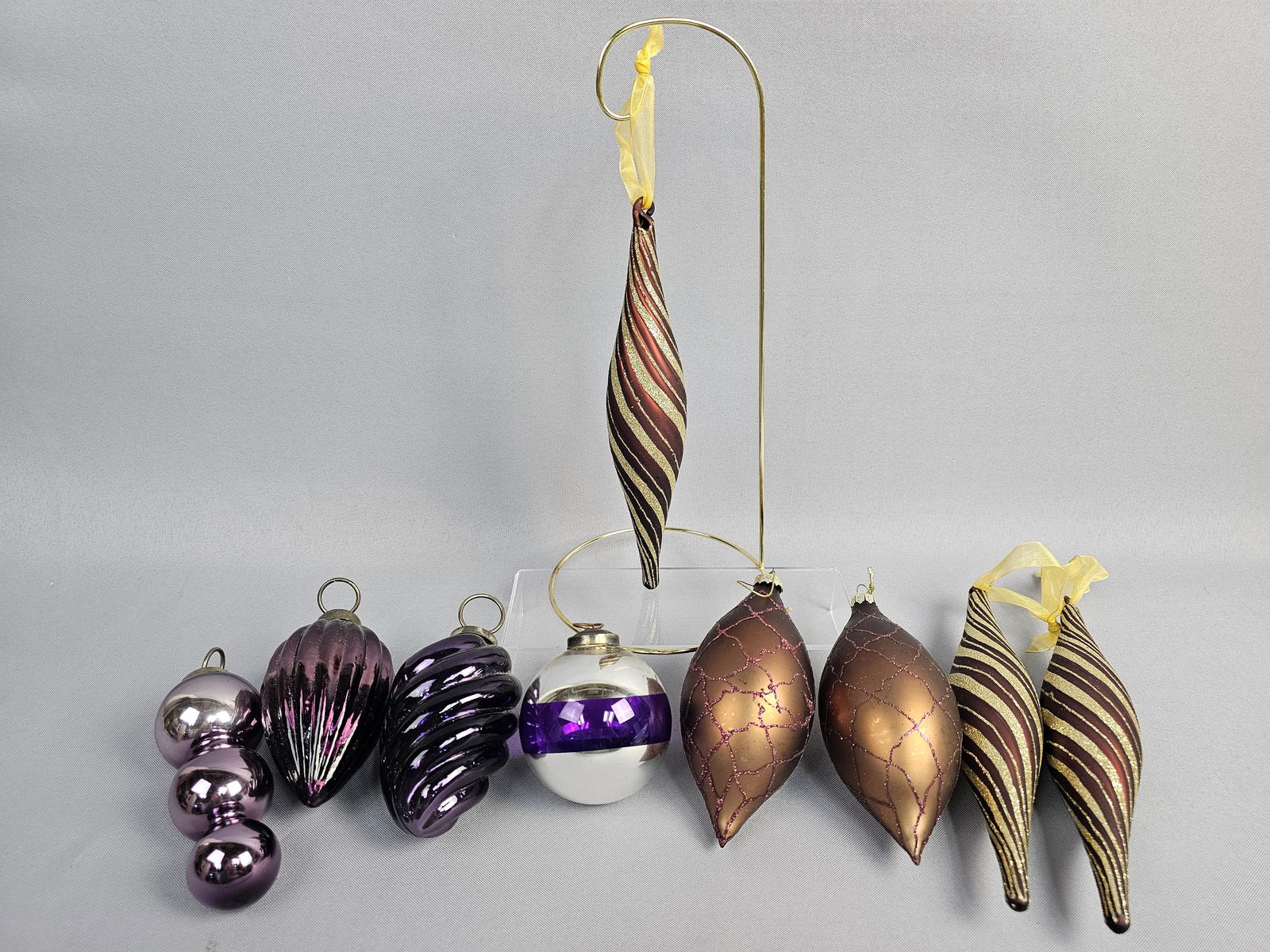Collection of Contemporary Blown Glass Holiday Ornaments in Metallic and Glitter Finishes: A collection of nine contemporary holiday ornaments crafted from blown glass with various metallic and glittered finishes. Dimensions: Largest drops 9 inches in length; teardrops approximately 6