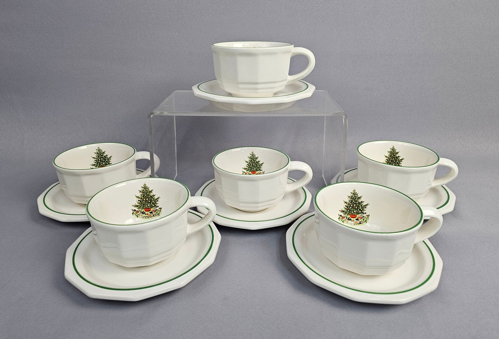 Six Pfaltzgraff Christmas Heritage Stoneware Cups and Saucers: A set of six cups and matching saucers manufactured by Pfaltzgraff in the classic Christmas Heritage pattern. Each piece is crafted from heavy stoneware with a characteristic octagonal body, finished