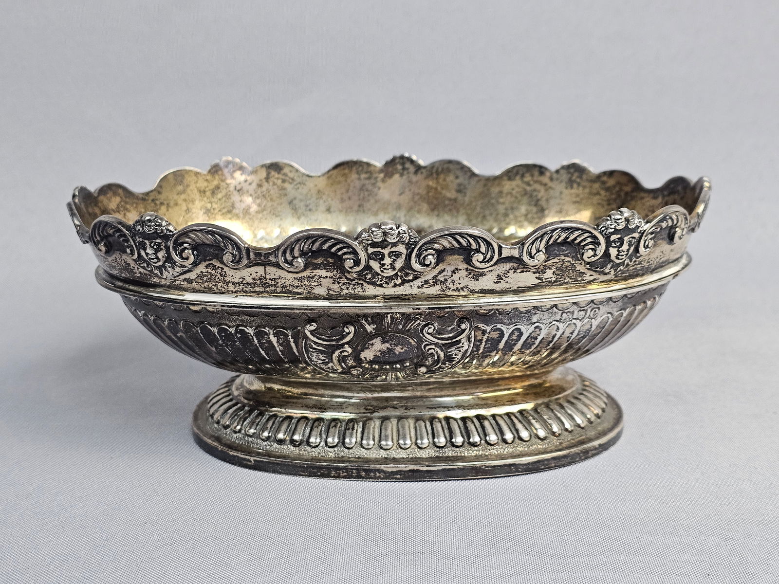German Neo-Renaissance Style Silver Footed Centerpiece Bowl: A fine German silver footed centerpiece bowl, likely Hanau in origin, dating to the late 19th or early 20th century. The oval vessel features a scalloped rim elaborately decorated with four repousse