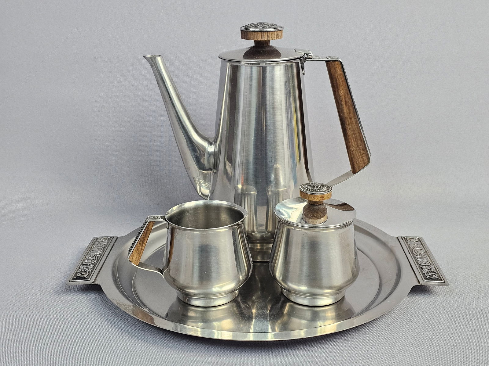 Mid-Century Modern International Decorator Stainless Steel Coffee Service: A four-piece coffee service produced by International Decorator, likely dating to the 1960s. The set is constructed from 18-8 stainless steel with a brushed finish and features distinctive Mid-Century