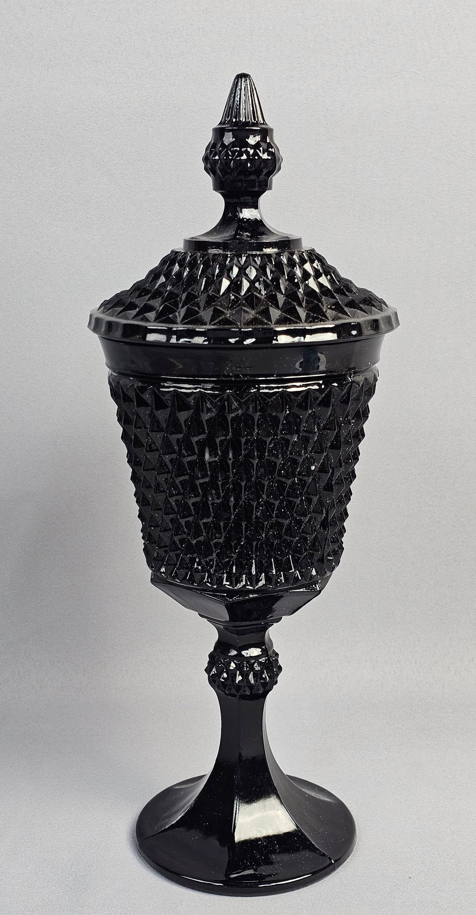 Tiara Exclusives, Pressed Glass, Lidded Diamond Point Chalice: This large, lidded chalice was produced for the retailer Tiara Exclusives and manufactured by the Indiana Glass Company. Executed in the Diamond Point pattern, the vessel features a dense, all-over te