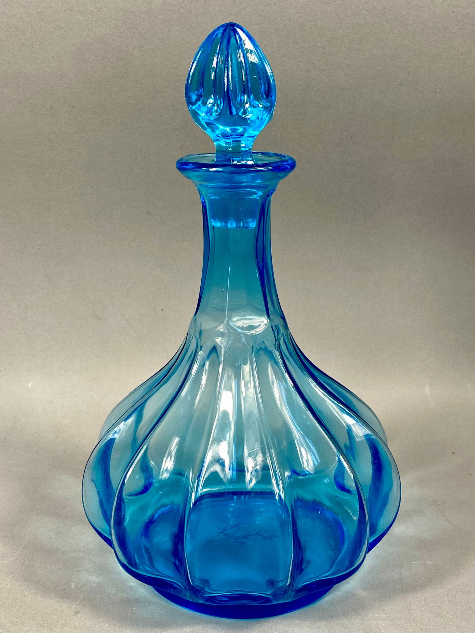 Tiara Exclusives Captain's Decanter and Stopper: This vintage glass decanter was produced for Tiara Exclusives, a prominent home-party plan marketing company, during the late 20th century. Crafted from light blue translucent glass, features a bulbou