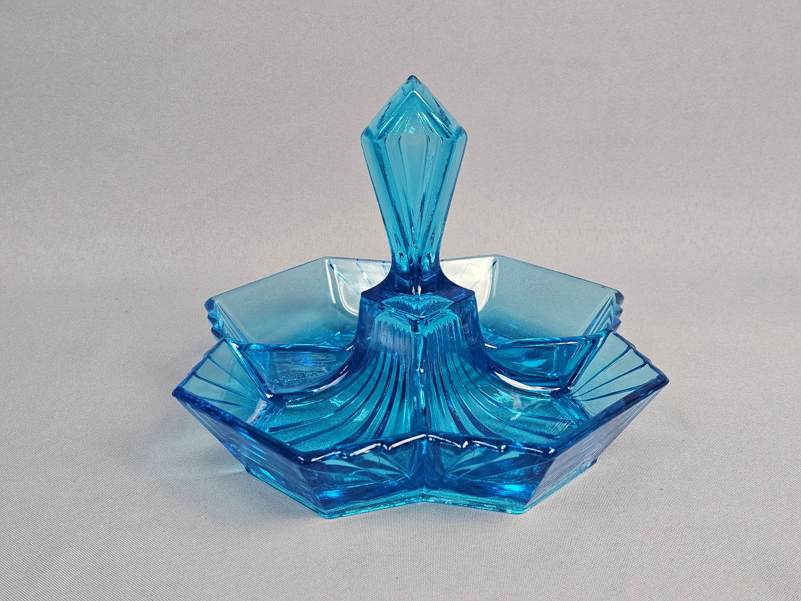 Indiana Glass Pyramid Pattern Art Deco Style Blue Pressed Glass Relish Dish Tray: A quintessential example of Art Deco glass design, this features a bold, hexagonal geometric form with sharp, radiating lines and a multifaceted, diamond-shaped finial handle. Measures 7.5 x 6 inches