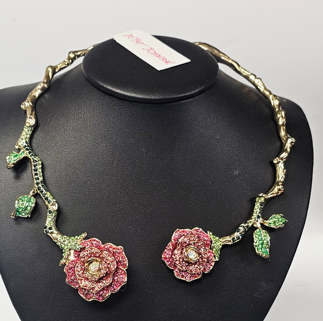 Betsey Johnson Crystal Rose Hinged Collar Necklace: This Betsey Johnson hinged collar necklace is crafted from gold-tone base metal and features a bypass design modeled as a thorny vine. The terminals are designed as two three-dimensional rose blooms,