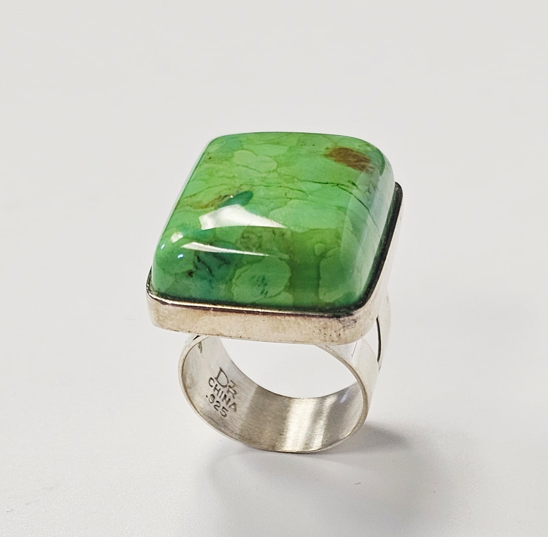 Jay King Sterling Green Turquoise Ring 18.6 Grams: A sterling silver cocktail ring featuring a large rectangular cabochon-cut stone. The stone is a variegated light green color with natural darker green and brownish-red matrix-like inclusions and visi