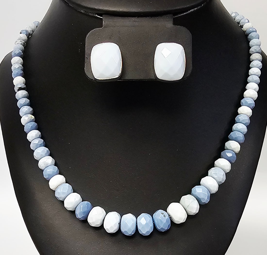 Sterling Faceted Blue Stone Necklace & Earrings: This jewelry set consists of a beaded necklace and a pair of matching stud earrings. The necklace is composed of faceted rondelle-shaped stones in mottled shades of light to medium blue and grey. The