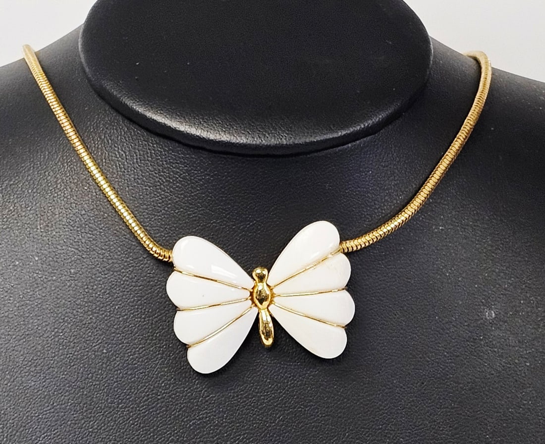 Crown Trifari Gold Toned Butterfly Pendant Necklace: A gold toned snake chain necklace featuring a butterfly pendant with white inset segments and a Trifari maker mark on the reverse, measuring approximately 1.5 inches wide. Measures 16 inches. Good Con