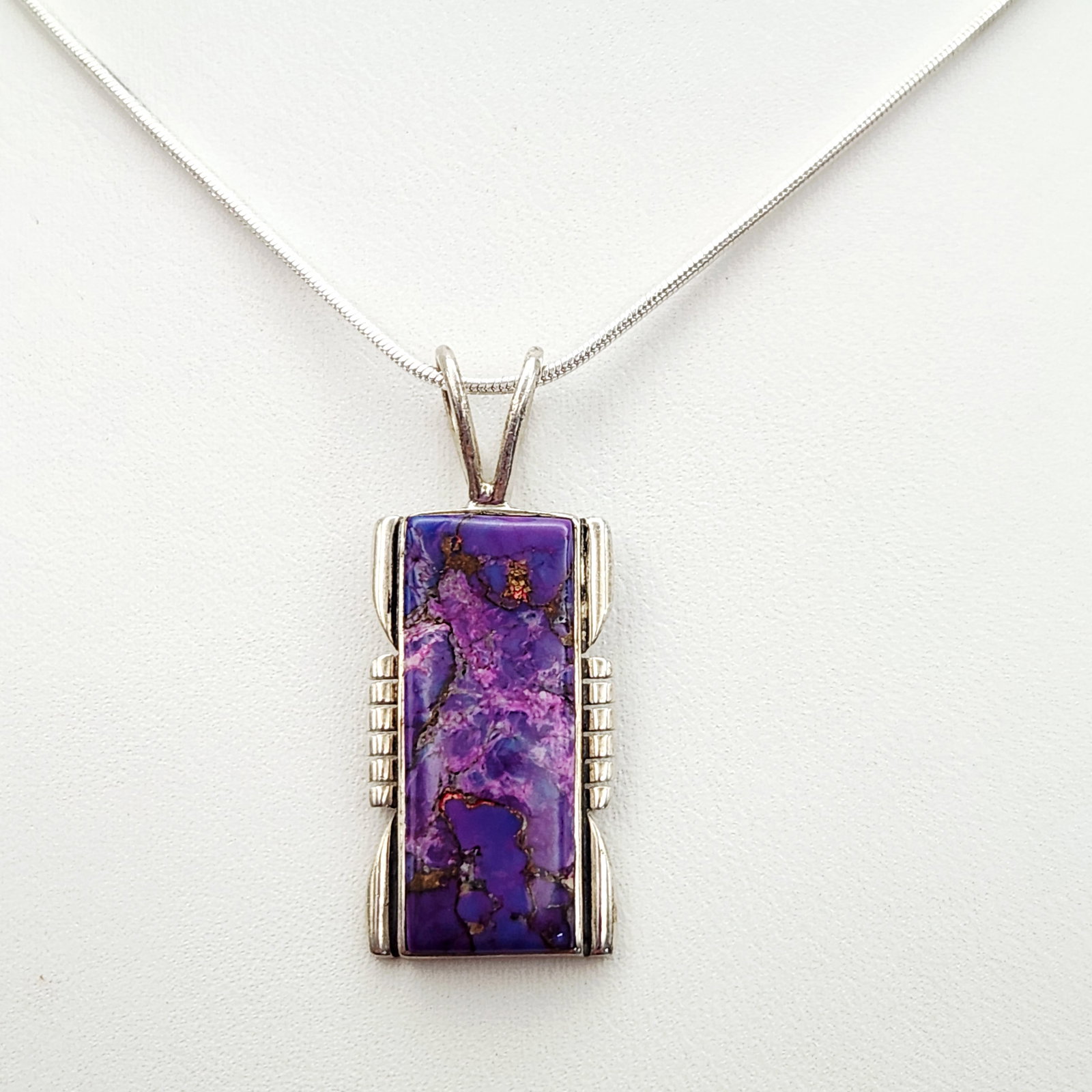 Sterling Purple Turquoise Necklace 9.2 Grams: A sterling silver snake chain necklace measuring 20 inches in length featuring a rectangular purple stone pendant marked 925 and Philippines. Weighs 9.2 grams. Very good condition.