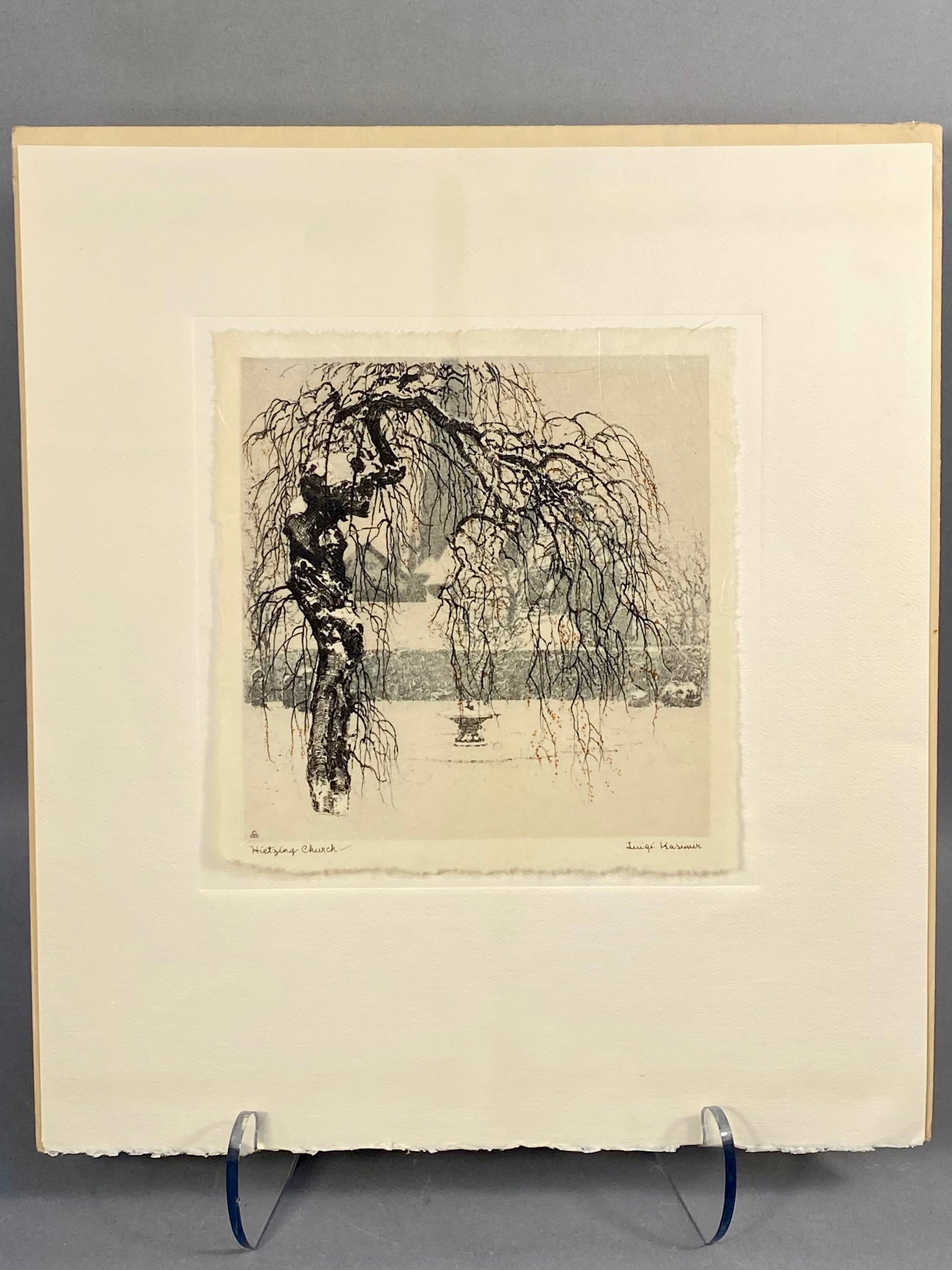 Luigi Kasimir, Hietzing Church, Color Etching and Aquatint: This color etching and aquatint on paper by Luigi Kasimir depicts a winter scene at Hietzing Church. The composition is dominated by a gnarled, snow-dusted tree with delicate weeping branches in the f