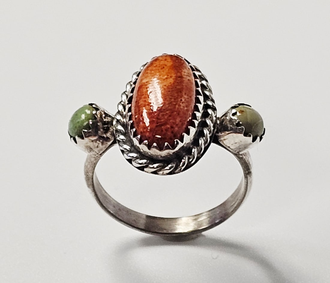 Running Bear Sterling Spiny Oyster & Turquoise Ring 3.4 Grams: A Southwestern style three-stone ring produced by Running Bear Trading Center of Gallup, New Mexico. The piece is constructed of sterling silver and features a central oval cabochon of reddish-orange