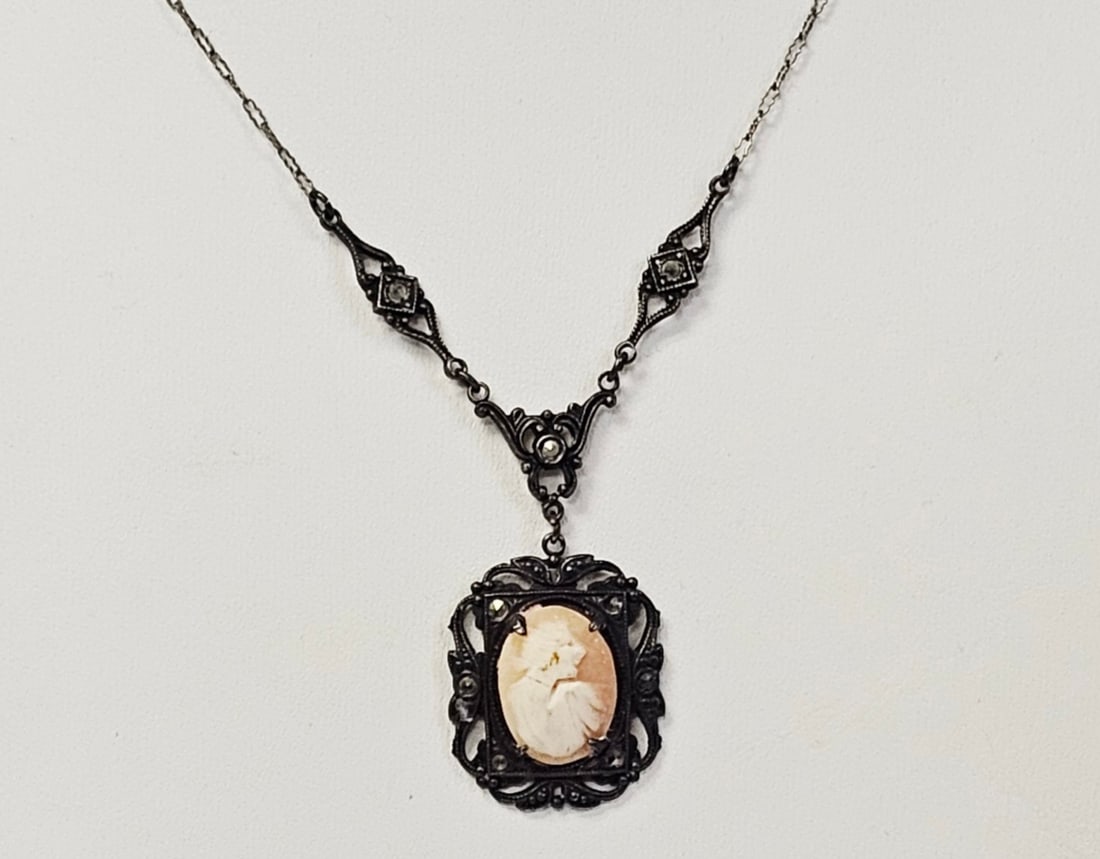 Antique Sterling Shell Cameo Pendant Necklace 6.6 Grams: This necklace features an oval shell cameo pendant depicting a woman's profile in a right-facing orientation. The cameo is prong-set within a sterling silver rectangular openwork frame. The frame and