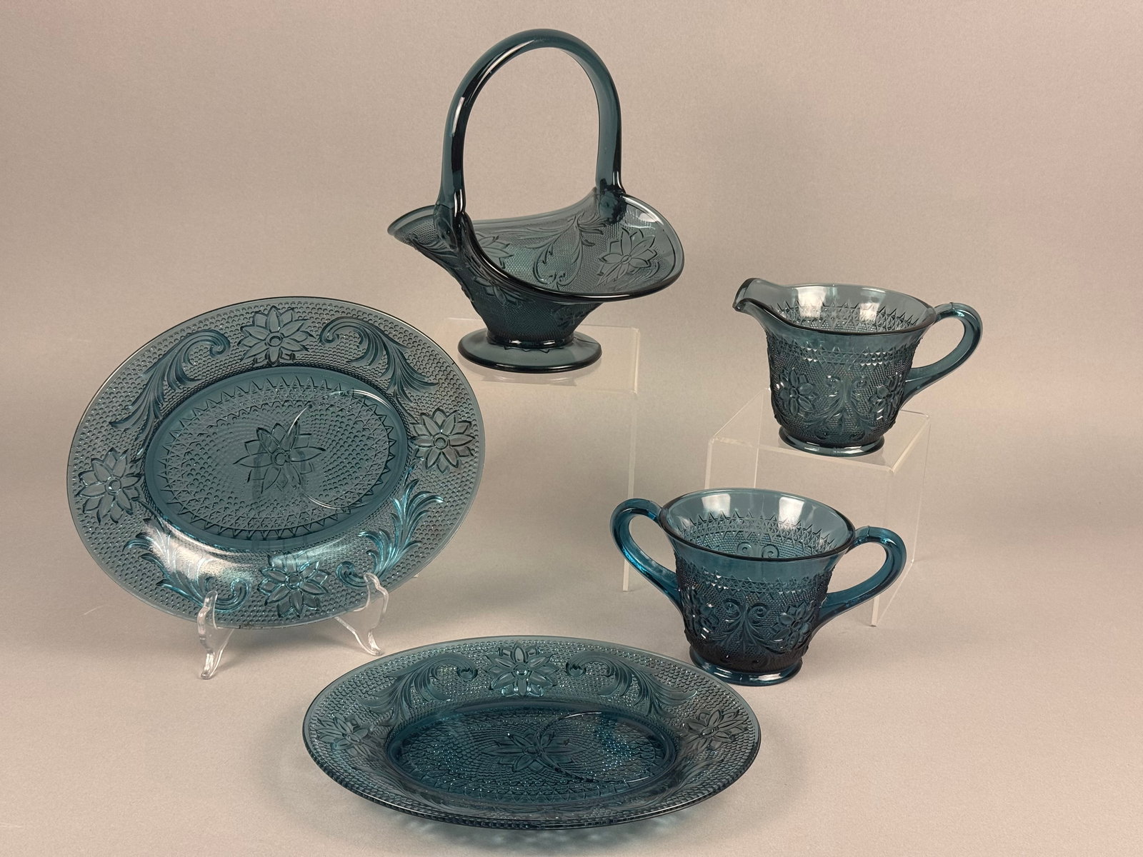 A Five-Piece Set of Sandwich Pattern Teal Blue Pressed Indiana Glass Tableware: This five-piece set of pressed glass tableware is in the Sandwich pattern, attributed to Indiana Glass for Tiara Exclusives. The set is produced in a dark teal blue color and features molded decoratio