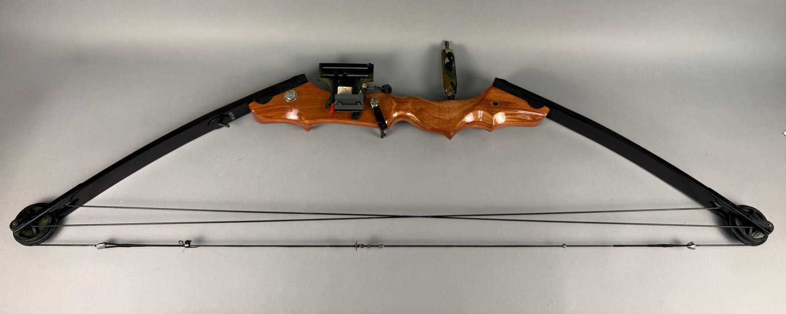 Bear Archery Kodiak Magnum Compound Bow: This Bear Archery Kodiak Magnum compound bow features a polished wood riser and black limbs. The limbs are marked with orange text reading BEAR and KODIAK MAGNUM, along with a logo box for Bear Archer