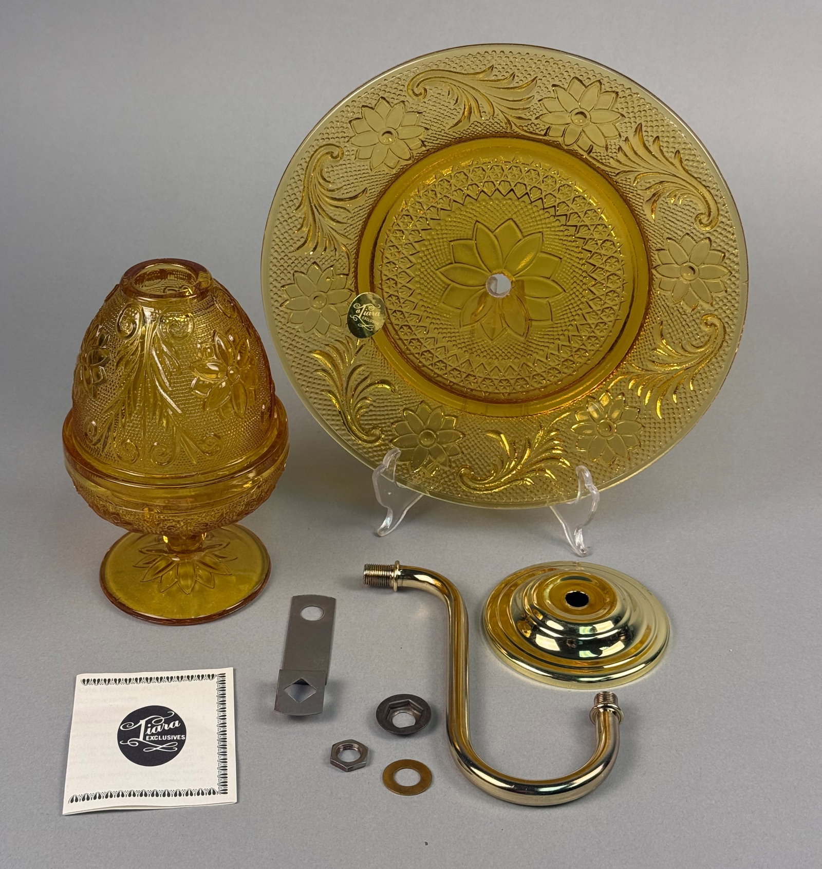 Tiara Exclusives Sandwich Pattern Amber Glass Wall Sconce Kit: This vintage wall sconce kit is produced in the Sandwich pattern for Tiara Exclusives. The set is crafted from amber pressed glass featuring a raised design of floral blossoms and scrolling foliate mo