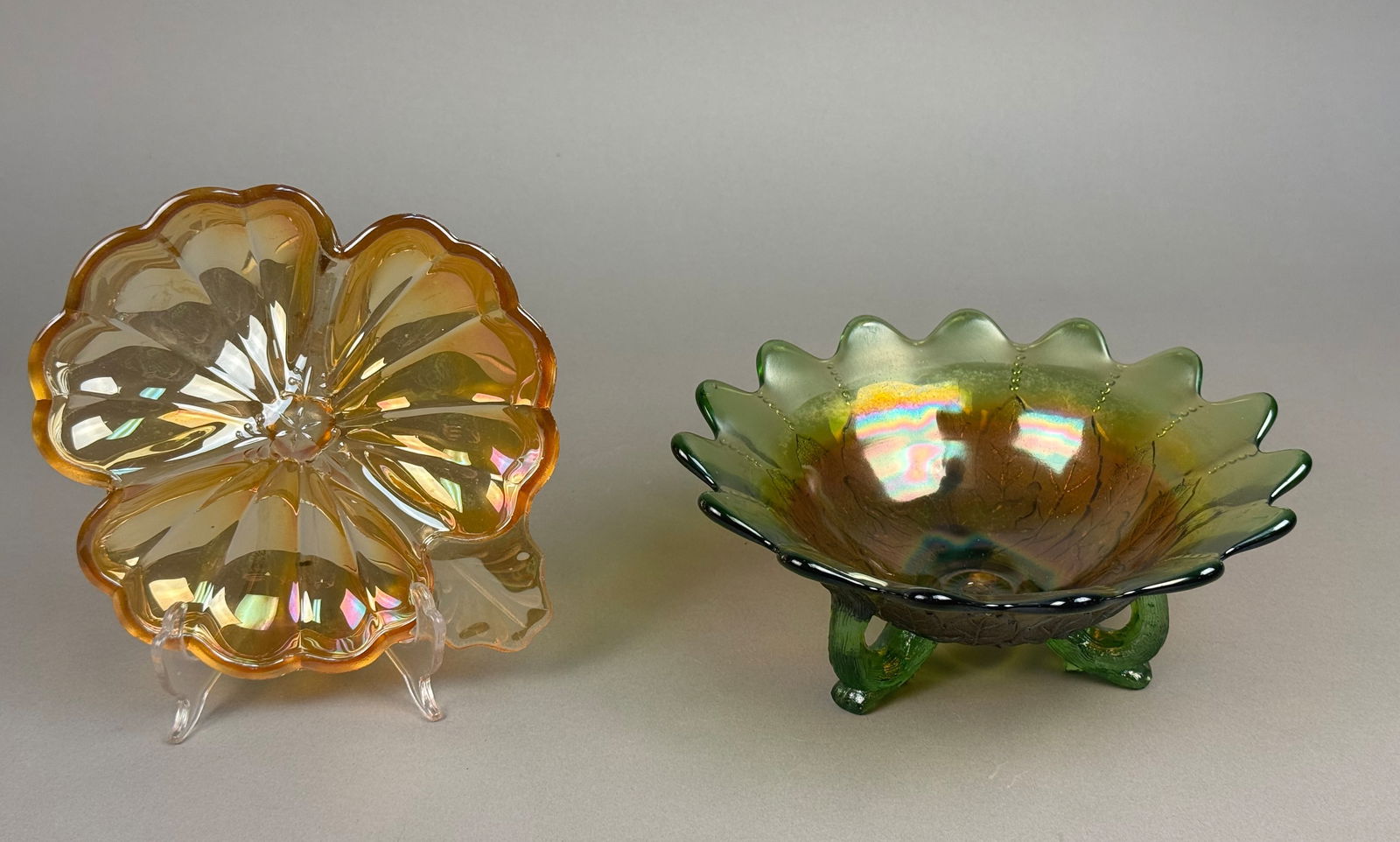 Two Pieces of American Carnival Glass: This lot features two pieces of iridescent pressed carnival glass. The first item is a green glass footed bowl featuring an embossed leaf design on the exterior, consistent with the Holly pattern. The